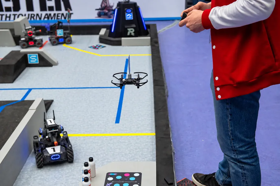 Соревнования по робототехнике: робот DJI RoboMaster и учебный дрон на поле